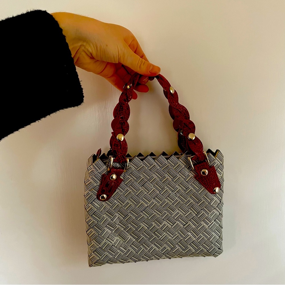 Nahui Ollin gum wrapper style bag with red handles.